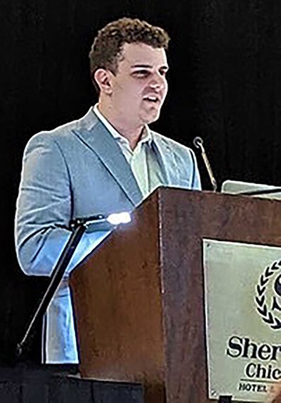 Photo of James O'Connor standing at a podium.