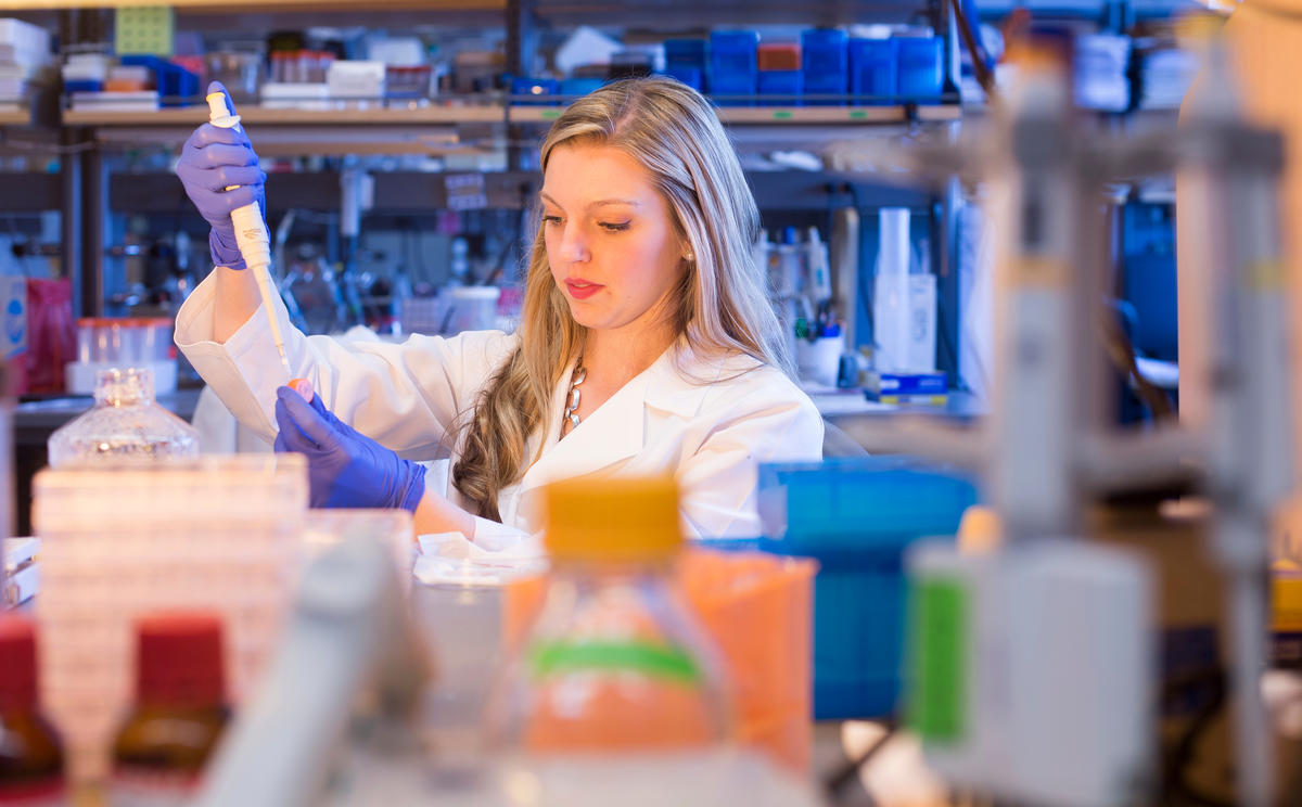 Lab member pipetting.