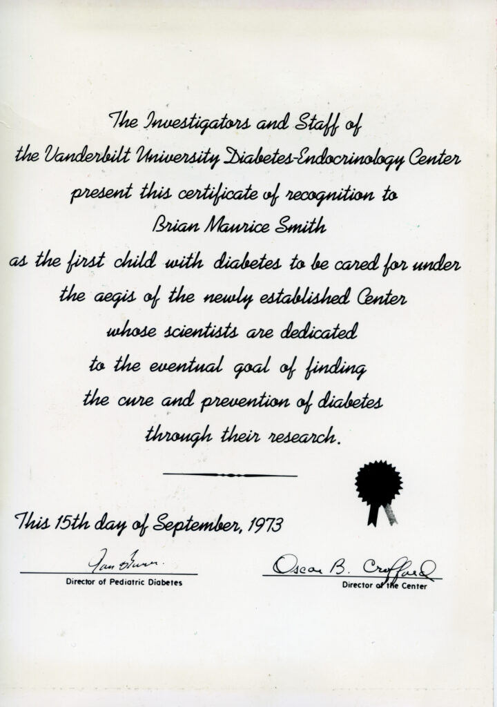 A certificate, which says "The Investigators and Staff of the Vanderbilt University Diabetes-Endocrinology Center present this certificate of recognition to Brian Maurice Smith as the first child with diabetes to be cared for under the aegis of the newly established Center whose scientists are dedicated to the eventual goal of finding the cure and prevention of diabetes through their research. This 15th day of September, 1973." It is signed by the director of pediatric diseases and the director of the center.
