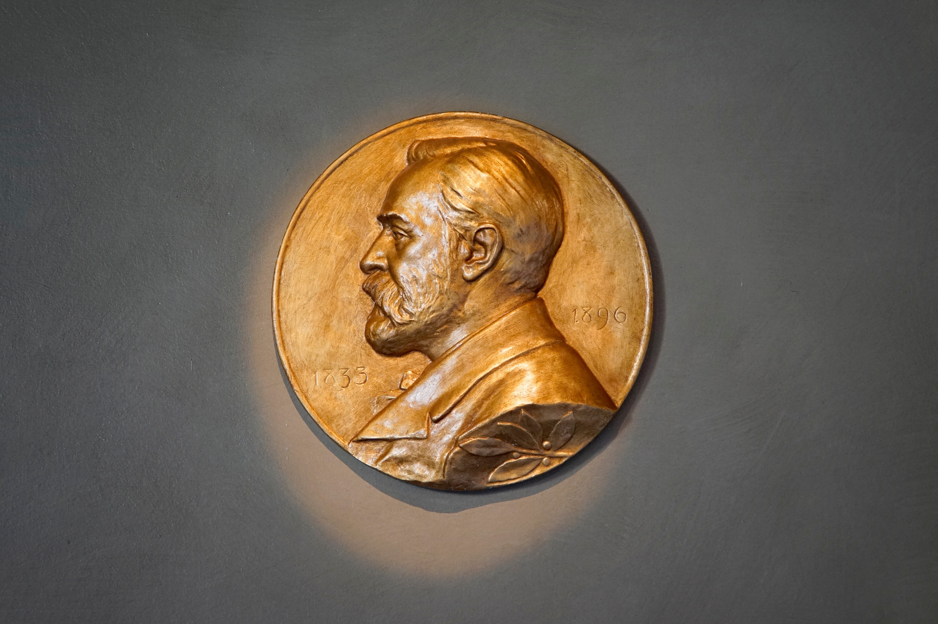 A Nobel medallion over a gray background.