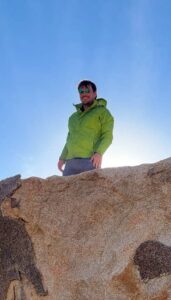 Photo of Manuel Castro standing on a large rock.