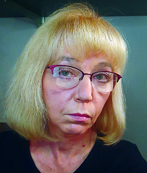 Headshot of Galina Lepesheva, who is wearing pink-rimmed glasses and a black top.