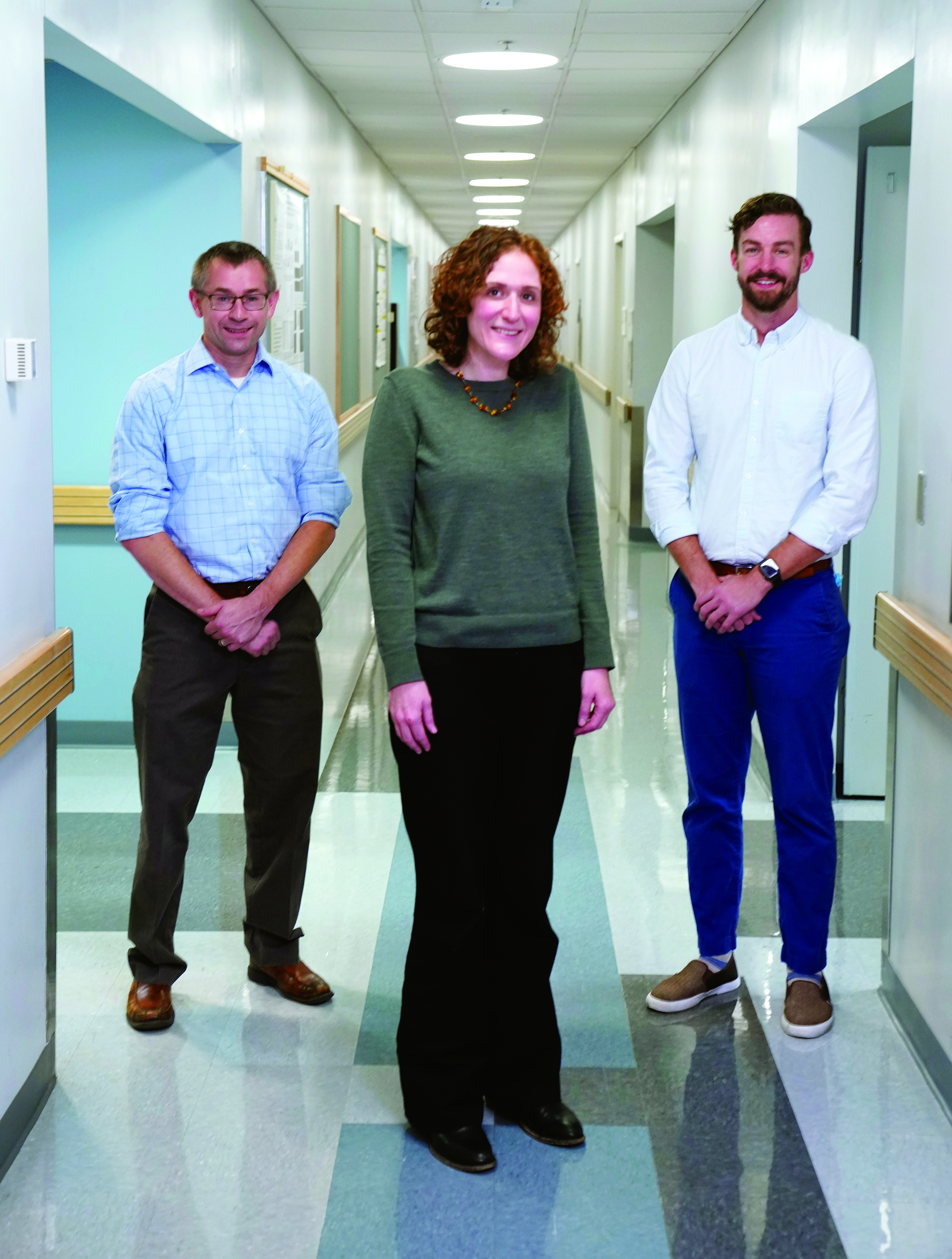 From left, Jonathan Kropski, Jennifer Sucre, and Bryce Schuler standing in a corridor.