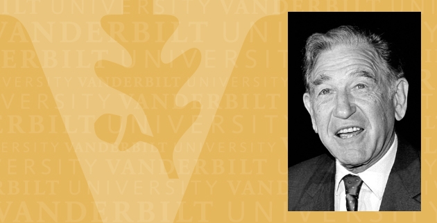 Gold-colored background watermarked "Vanderbilt University" featuring a large oak-leaf V on the left and an image on the right. The image is a black and white photo of Stanley Cohen, from the shoulders up. He's wearing a white, collared shirt and a tie and is mid-speech.