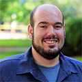 Headshot of Alex Guseman wearing a blue shirt.