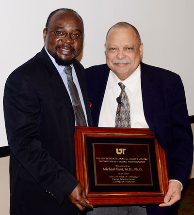 Photo of Dr. Samuel Dagogo-Jack (left) presenting Michael Fant (right) with an award plaque.
