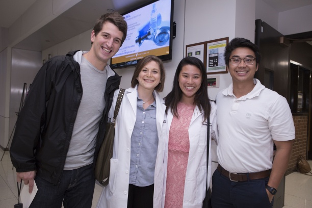 Epidemiology Ph.D. Students Lauren Saag and Jaimie Shing receive their white coats at the Simple Beginnings Ceremony