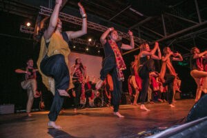 Students in costume dance on a stage