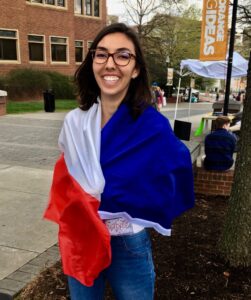A woman poses draped in a flag