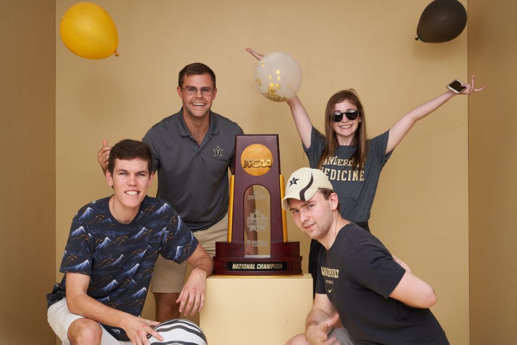 Four people pose with a trophy