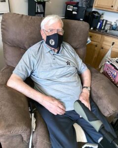 A man wearing a Vanderbilt polo sits in a recliner