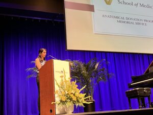 A young woman stands behind a podium to speak