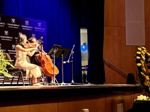 Two students play stringed instruments