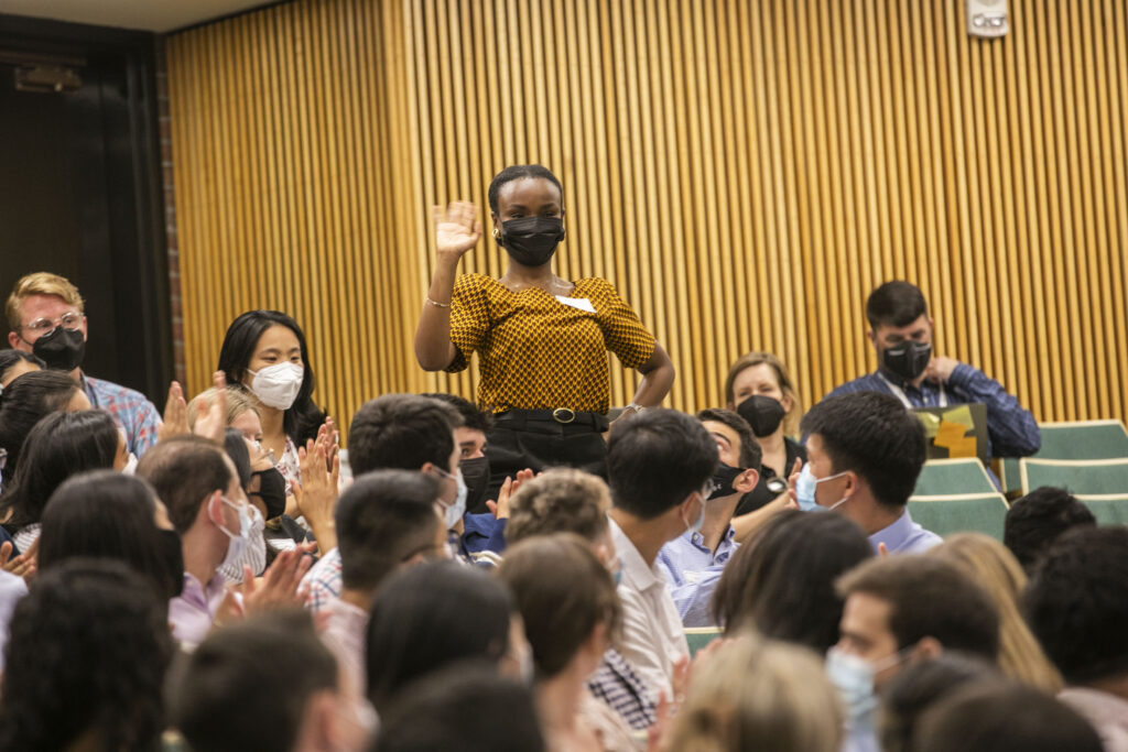 A woman in a mask stands up and waves