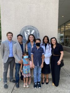 A family stands in front of an outdoor medical school seal