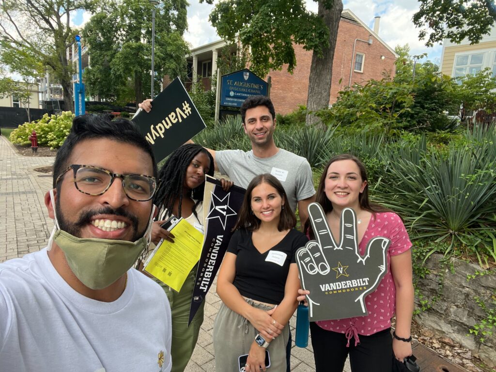 Master of Public Health students pose with festive signs and banners during an orientation photo challenge